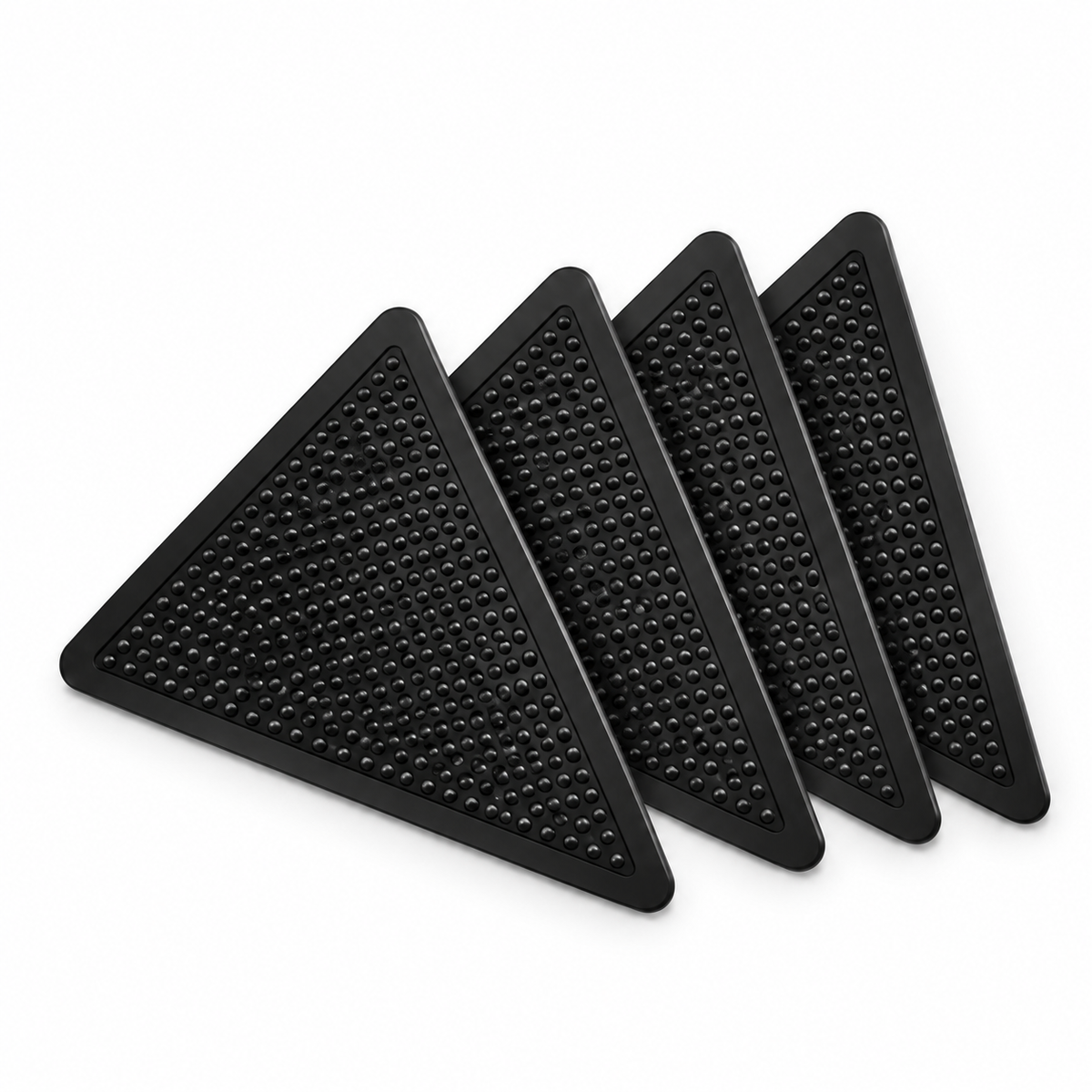 Four black triangular Mountly rug grippers on a white background