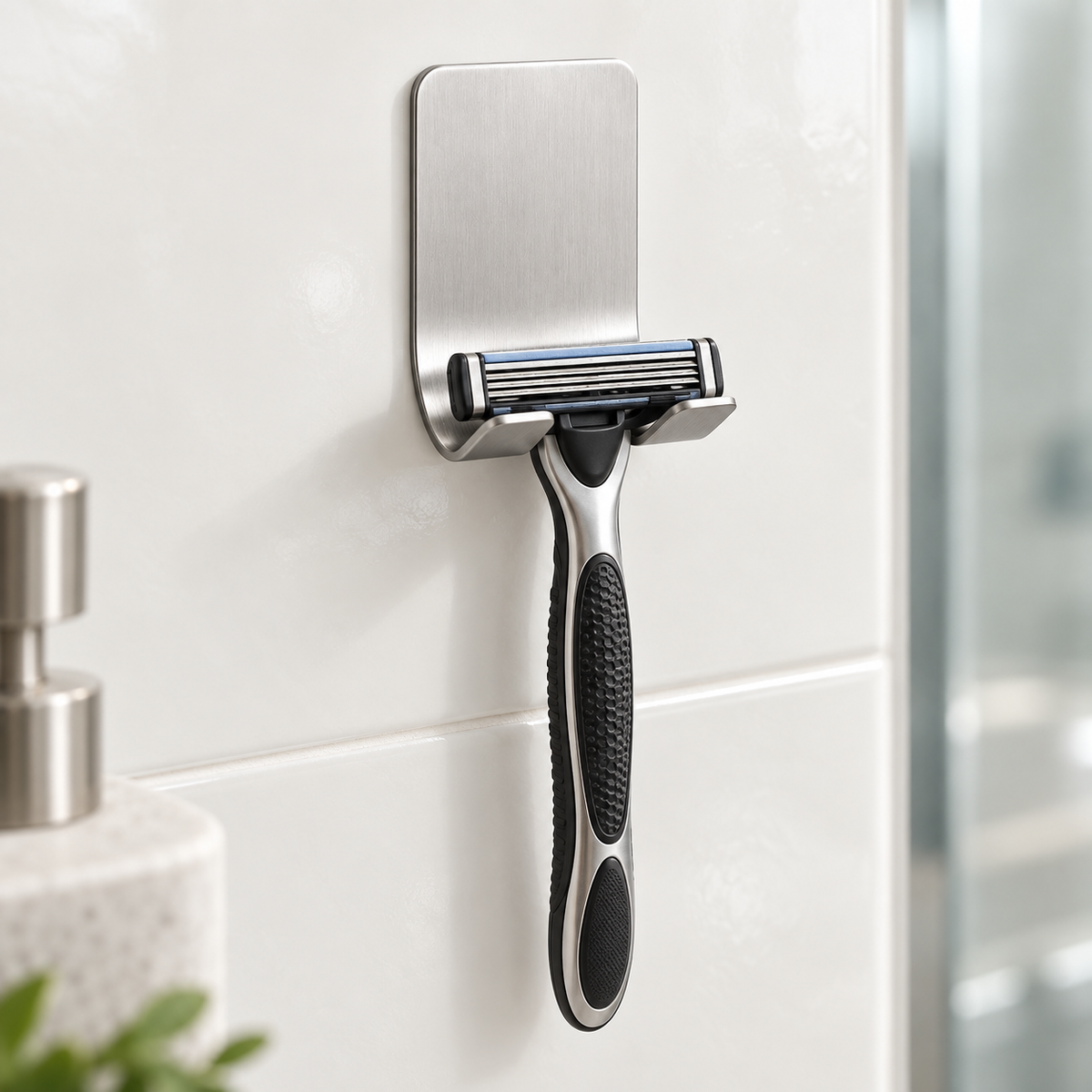 Silver Mountly razor holder on a bathroom wall supporting a manual razor, handle facing down. Razor not included.